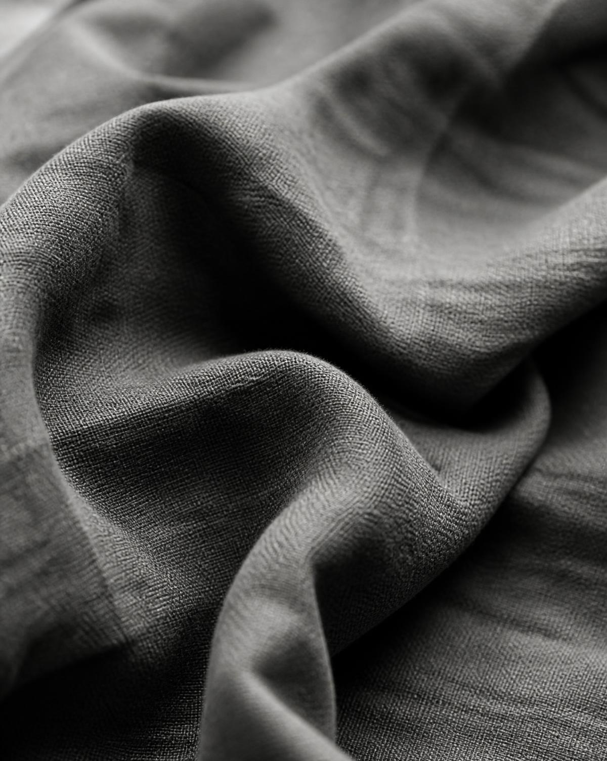 Monochrome close-up of folded heavy linen in raking light