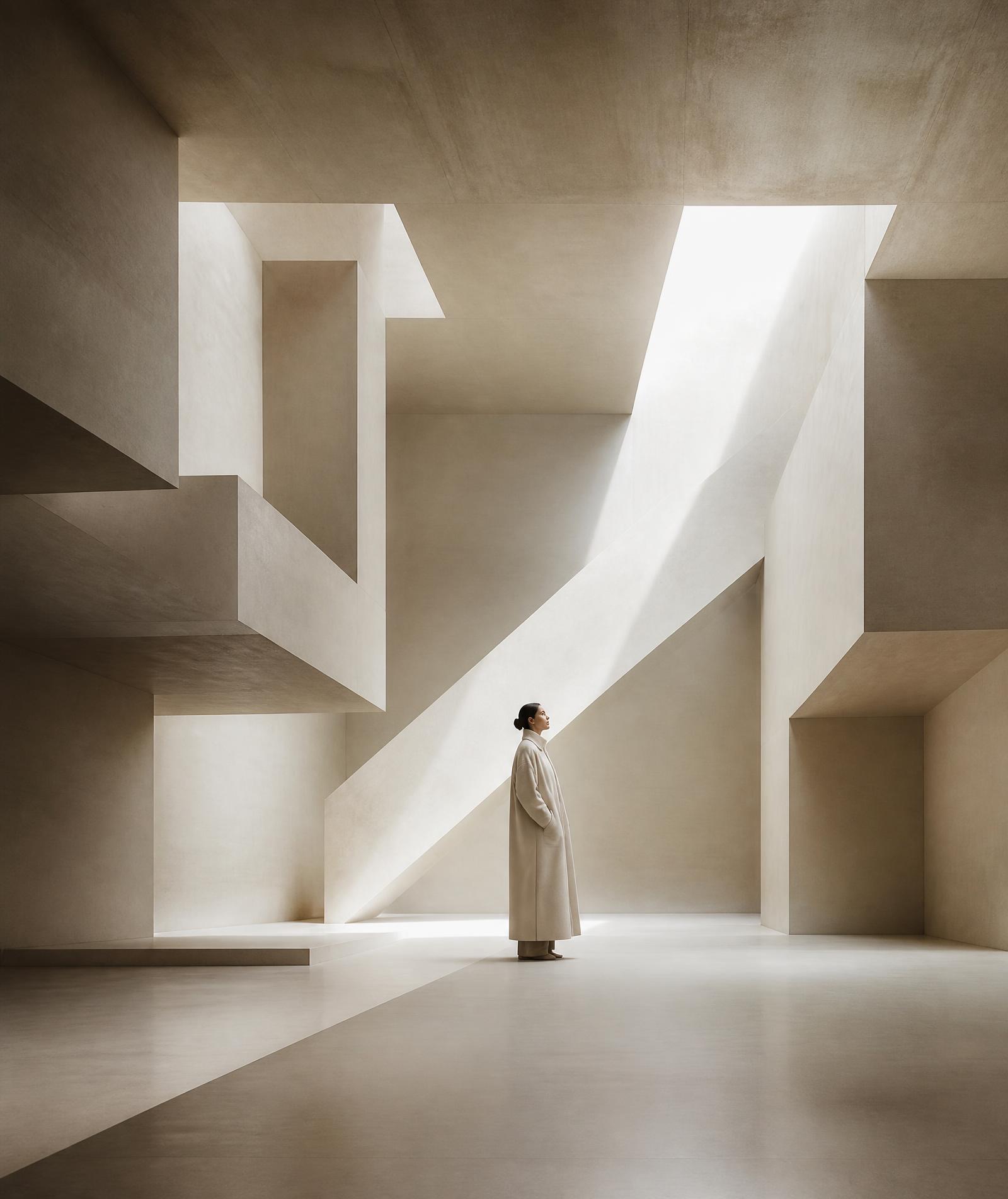 A solitary figure in a long coat inside monumental impossible architecture